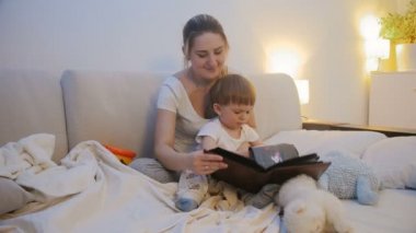 Genç Anne aile albümü yatmadan önce izlerken fotoğraflarda 4 k görüntüleri