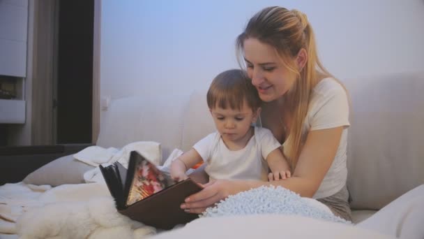 4k Filmmaterial von Mutter zeigt ihr Baby altes Familienalbum — Stockvideo