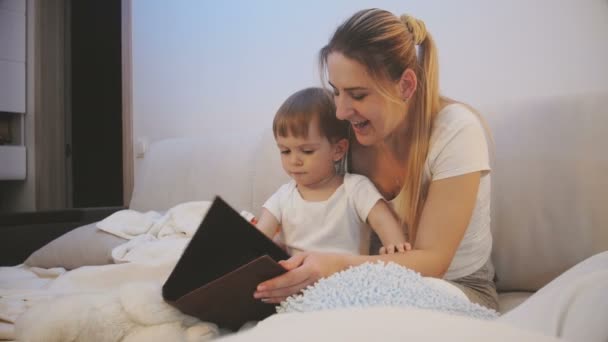 Vidéo 4k de la mère lisant l'histoire du coucher à son fils bébé — Video