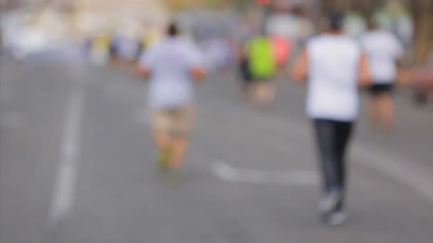 Tiro desfocado de volta do grupo de corredores na maratona da cidade — Vídeo de Stock