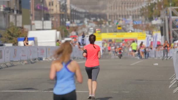 Şehir caddesinde maraton koşucularının arkadan görüntü atışı — Stok video