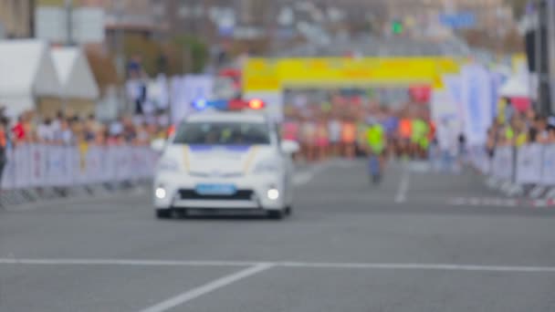 Politieauto draait op de lampjes op de marathon van de stad — Stockvideo