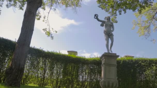 Hermosa estatua antigua en el jardín bajo un gran árbol — Vídeos de Stock