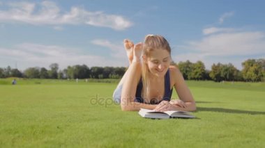 Dolly Park'ta çim üzerinde yalan ve bir kitap okuma güzel gülümseyen kadın vurdu