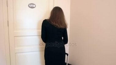 Arka görünümü atış genç kadının otel odasının kapısını anahtarla açar.