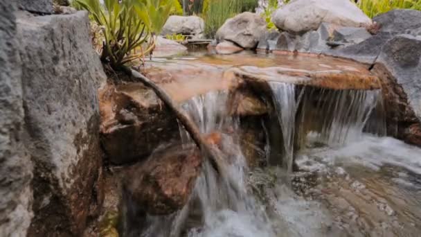 Serene jelenet víz folyik át sziklák, a kertben — Stock videók