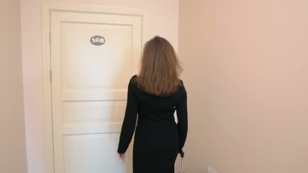 Elegante vrouw in jurk aankomen hotel te openen deur met sleutel — Stockvideo