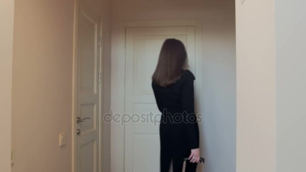 4K video de la hermosa mujer joven con la maleta caminando en el dormitorio — Vídeo de stock