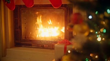 Arka plan ile dekore edilmiş Noel ağacı ve yanan şömine, oturma odası. Şömine üzerinde odaklanmak