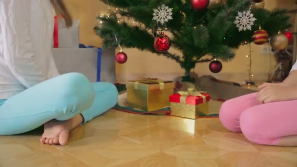Gros plan de deux filles regardant à l'intérieur de boîtes-cadeaux de Noël — Video