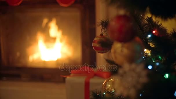 Imagen de cerca de adornos dorados y rojos en el árbol de Navidad. Quema de chimenea en el fondo . — Vídeos de Stock