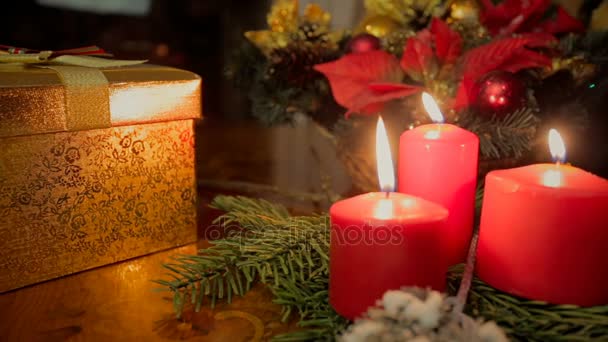 Primer plano de la muñeca de tres velas encendidas y regalos de Navidad en la sala de estar — Vídeos de Stock