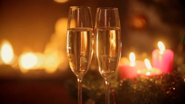 Deux verres de champagne sur la table devant une cheminée en feu la veille de Noël . — Video