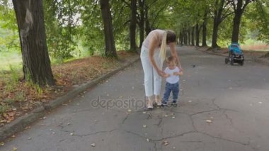 Bebek oğluyla Park'ta yürüyüş ve güvercin besleme genç anne