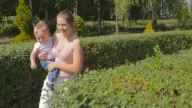 Çalışan ve bebek oğlu ile parkta oynayan neşeli genç anne