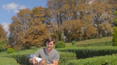 Sarılma ve bebek oğlu ile parkta oynarken mutlu genç Baba