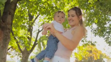 Mutlu genç anne bebek oğlu sarılma ve giving onu bir yaprak portresi