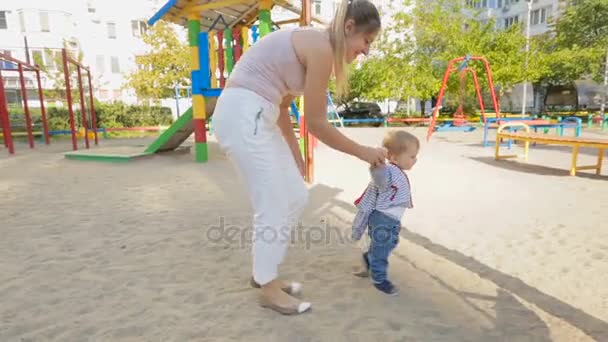 Schattige babyjongen lopen met zijn moeder op de speelplaats — Stockvideo