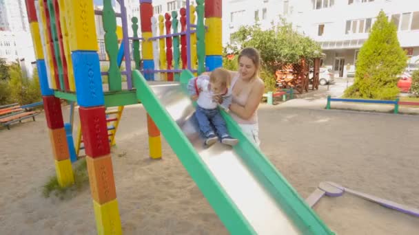 Entzückender kleiner Junge reitet mit Mutter auf der Rutsche — Stockvideo