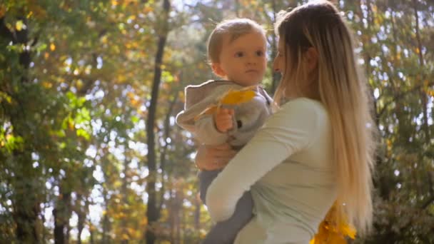 Slow motion close-up shot van moeder met zoontje op herfst park — Stockvideo