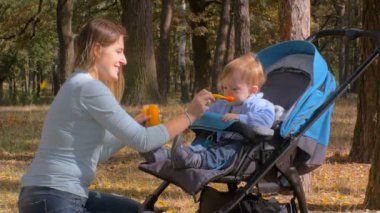 şirin bebek çocuk arabası park ve yeme elma sosu oturan 4 k görüntüleri