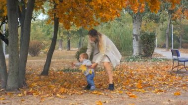 Şirin bebek çocuk oynamaya ve annesiyle birlikte sonbahar Park'ta yürüyüş