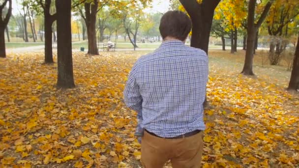 Zeitlupe zeigt glücklichen Vater, der seinen kleinen Sohn im Herbstpark umarmt und dreht — Stockvideo