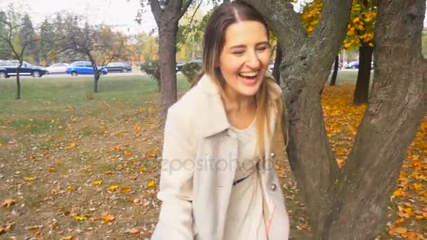 Mouvement lent de la jeune femme ludique jouer et fuir au parc d'automne — Video