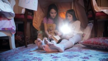 4 k dolly atış iki kız teepee çadırda el feneri ile kitap okuma