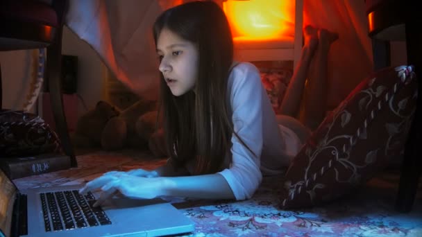 Dolly video di giovane ragazza che utilizza il computer portatile a tarda notte in camera da letto — Video Stock