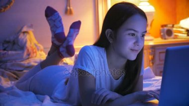 Mutlu genç kızlar skype veya video messenger üzerinden laptop yatak konuşmayı gülümseyen