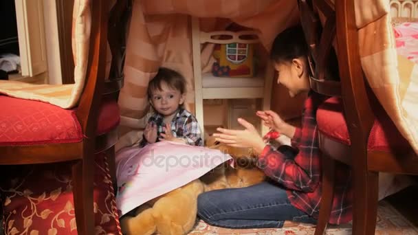 Cute toddler boy dancing and clapping hands with his elder sister in diy tent — Stock Video