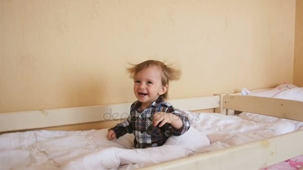 Vídeo en cámara lenta de feliz adorable niño saltando en la cama — Vídeo de stock