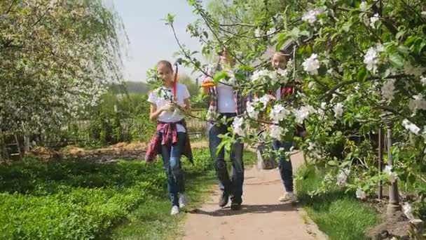 4K rekaman keluarga bahagia berjalan dengan alat berkebun setelah bekerja di kebun — Stok Video