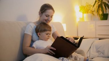 Anne bebek oğlu yatakta için kitap okumak 4 k görüntüleri