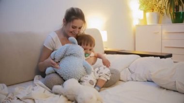 Yaramaz bebek çocuk yorgun anne onu yatakta koymak için çalışırken süre uyku reddediyor
