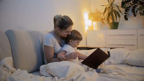 4 k beelden van leesboek moeder aan haar zoon baby — Stockvideo