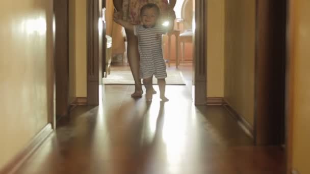 Feliz menino sorridente andando com a mãe em casa — Vídeo de Stock