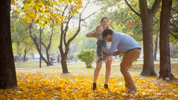 Filmato al rallentatore di felice giovane padre che corre da sua moglie con il bambino e li abbraccia al parco — Video Stock