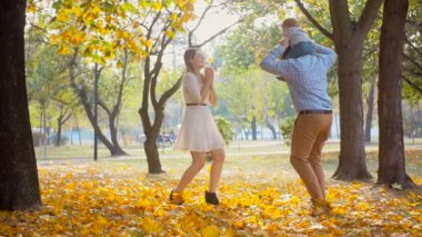 Sonbahar park adlı bebekle oynarken mutlu genç aile
