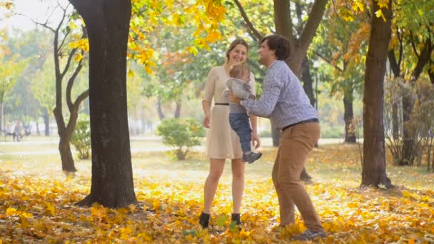 快乐年轻的父亲拥抱和解除他的宝贝儿子在公园里的慢动作镜头 — 图库视频影像
