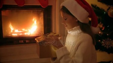 Parlak Noel hediye kutusu içinde seyir Santa şapkalı kız mutlu portre portre