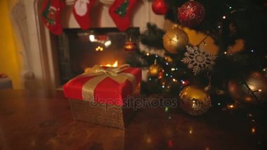 Dolly kadeh kırmızı Noel hediye kutusu masada oturma odasında şömine ile altın yay ile