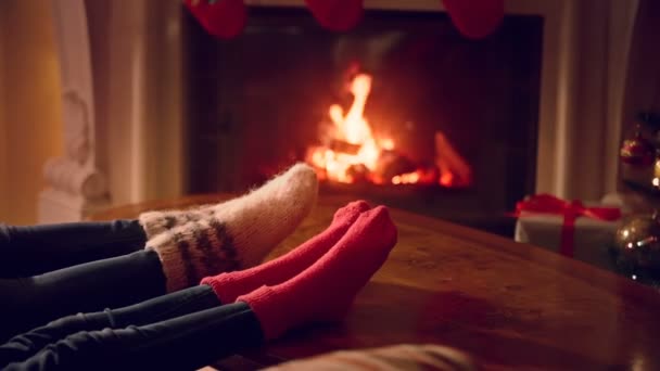 Zbliżenie stóp płci męskiej i żeńskiej w Skarpety wełniane ocieplenia przy kominku — Wideo stockowe