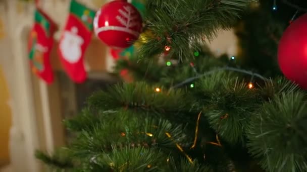Closeup steadicam schot van mooi versierd kerstboom op woonkamer met open haard — Stockvideo