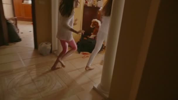Dwie dziewczyny wesoły działa na prezenty pod choinkę na rano — Wideo stockowe