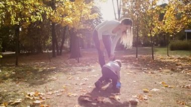 Topu tutan bebek oğlu ile parkta yürüyüş güzel genç anne