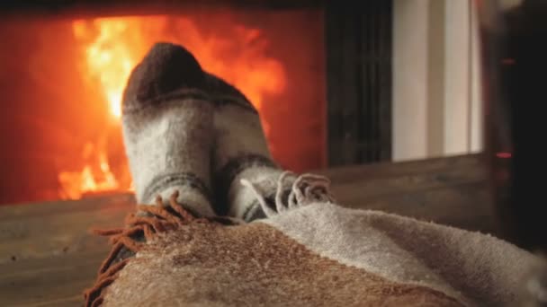 Медленное движение видео женщины в шерстяных носках расслабляющей у камина и пить горячий чай — стоковое видео