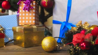 Sağdan sola hediye kutuları, parlak ışıklar ve Noel ağacının altında yalan baubles pan