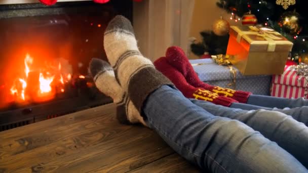 リビング ルームの暖炉の横に横になっているウールの靴下の中の家族の 4 k 映像がクリスマスの装飾 — ストック動画